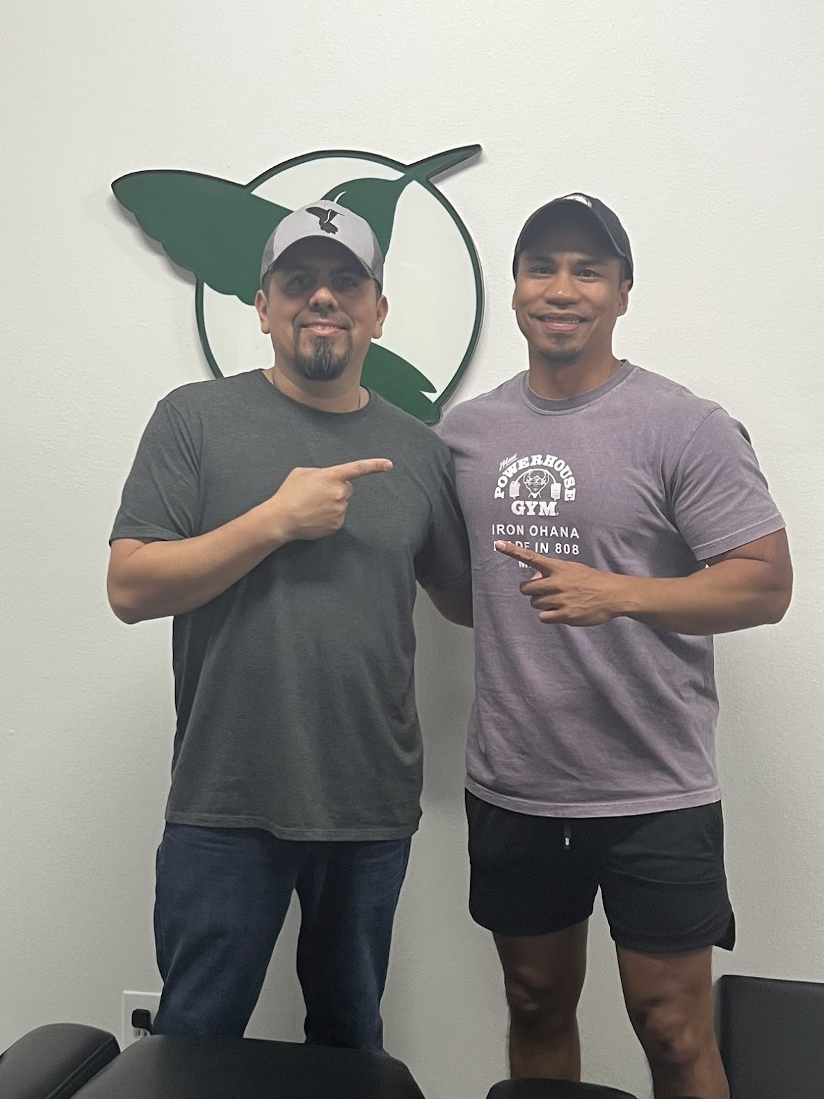 Dr. Sam with an athlete in front of the hummingbird logo